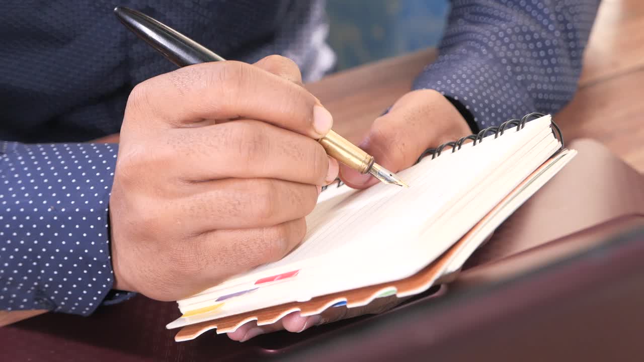 Person Writing in a Notebook