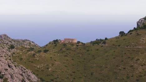 fotografía reveladora de una pequeña casa y una carretera en el paso de la colina en la isla de mallorca, vista aérea