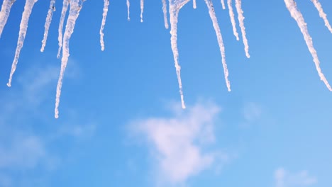 icicles hanging from a roof against a blue sky