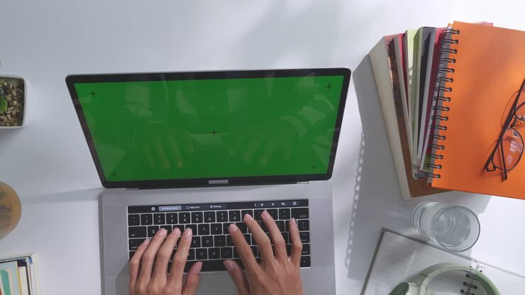 Person, die an einem Schreibtisch an einem Laptop arbeitet
