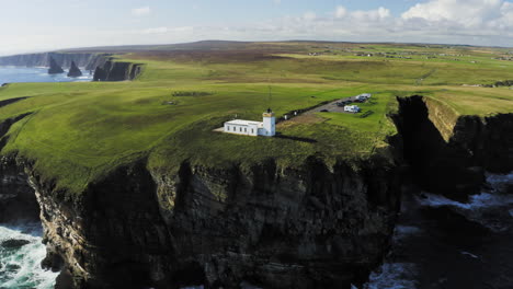 spectacular droneshotof cliffs at duncansby head lighthouse going out into ocean