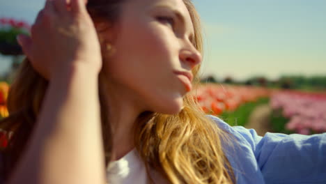 beautiful girl making selfie in flower field. young woman looking at camera.