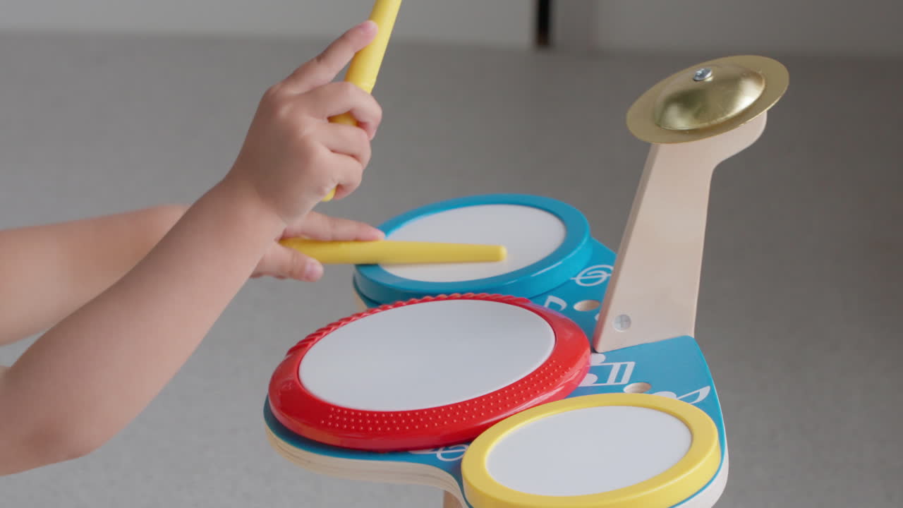 Young girl playing music on toy drum set