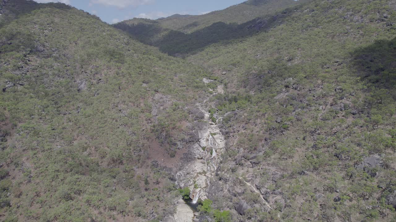 vista aérea de las cataratas de emerald creek rodeadas de rocas de granito y vegetación verde en mareeba, australia - disparo de drones
