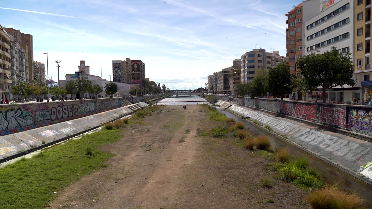lecho seco del río en la ciudad urbana con graffiti en las paredes