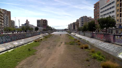 Lecho-Seco-Del-Río-En-La-Ciudad-Urbana-Con-Graffiti-En-Las-Paredes