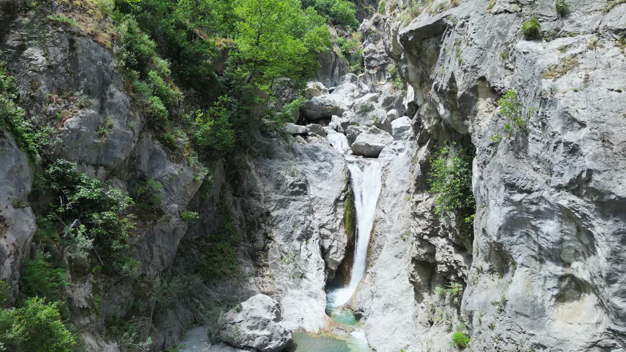 Aerial drone footage of Gole Ranciara, Sicily: rocky canyon with turquoise river, lush vegetation, and dramatic cliffs. Perfect for nature, adventure, and travel documentary projects