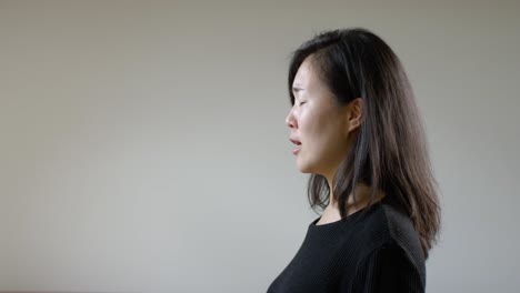 asian woman sneezing during corona virus pandemic from side
