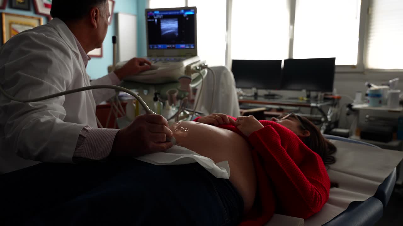 Gynecologist performing a check-up on a pregnant woman with ultrasound