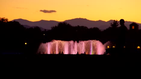 fuente de agua iluminada en cámara lenta contra un fondo del horizonte de denver