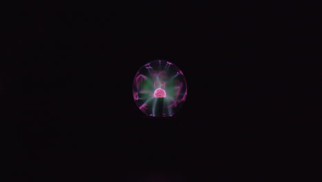 this is a far shot video of a plasma globe running with a black background