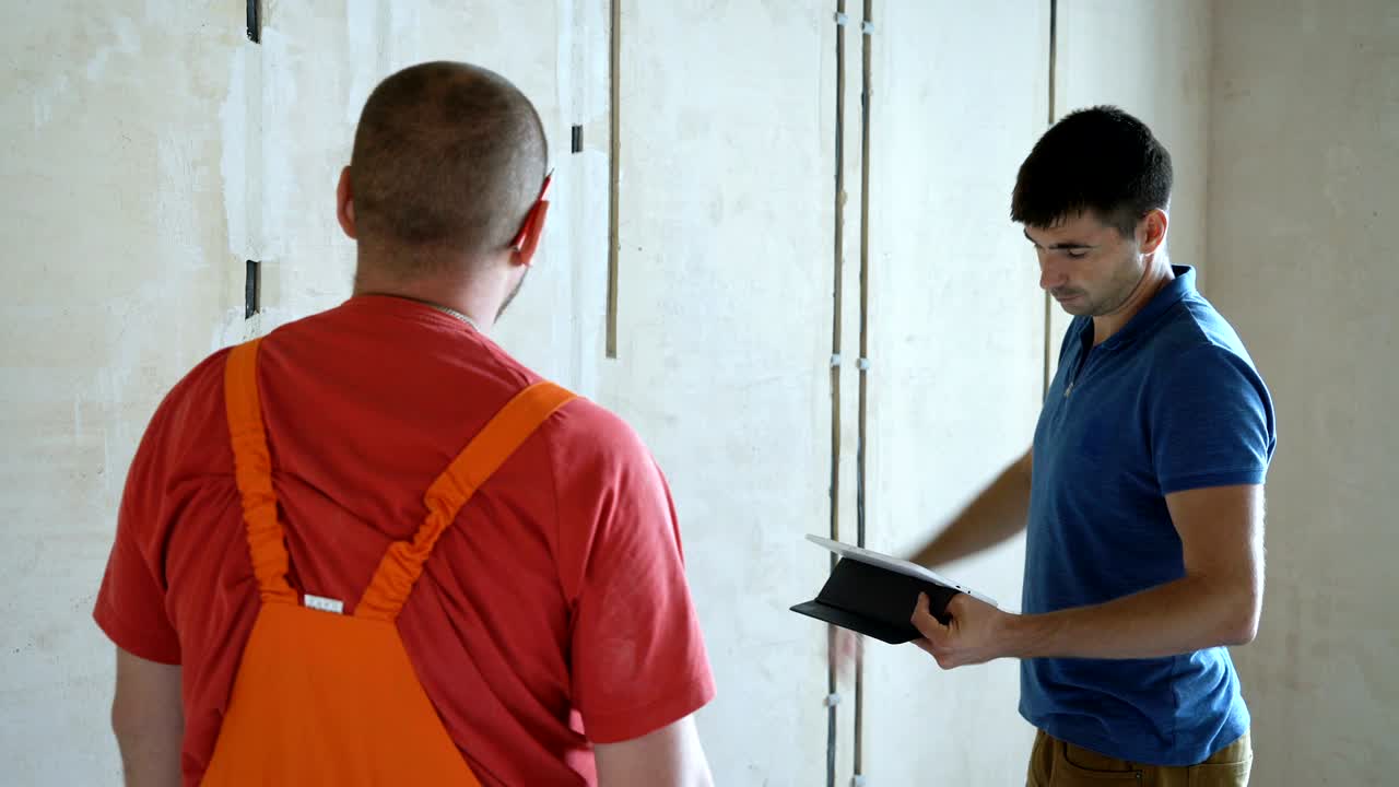 ingeniero y arquitecto discutiendo a través de una tableta inalámbrica digital trabajando en el sitio de construcción interior