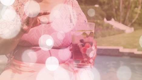 holding drink with berries and mint, person relaxing by pool, bokeh animation