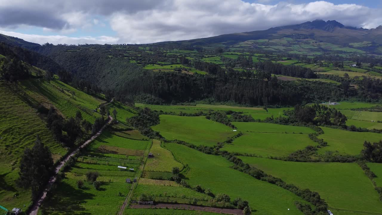 Sorvolo con drone aereo di campi coltivati a mosaico verdi sui pendii e ai piedi delle montagne al vulcano Pasochoa, Puichig, valle di Machachi, Cantone Mejia, Provincia di Pichincha, Ecuador