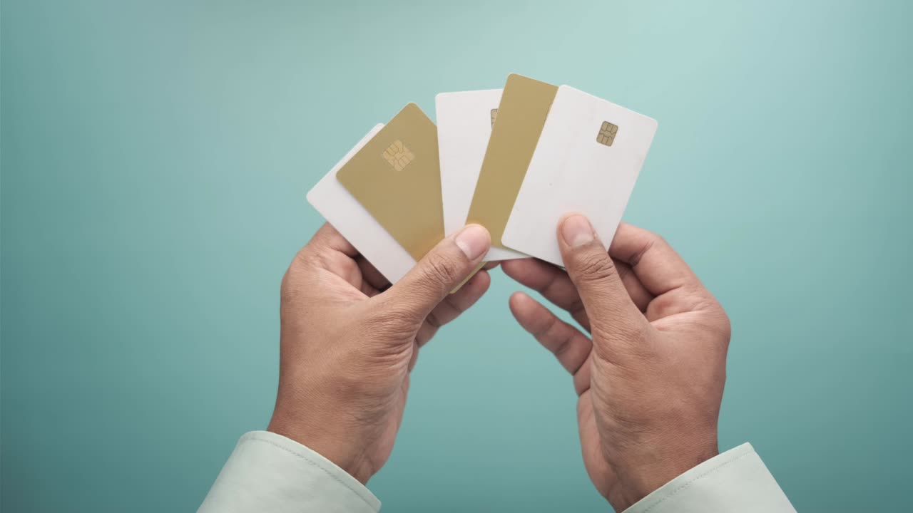 верхний вид руки человека, держащего много кредитных карт