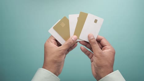 vista superior de la mano de una persona que sostiene muchas tarjetas de crédito