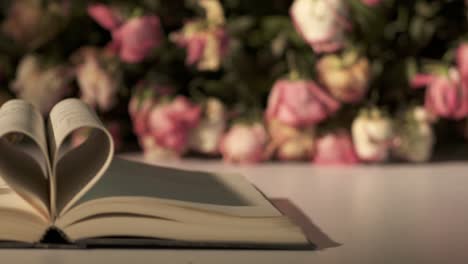 bouquet of withered rose flowers and open book with heart