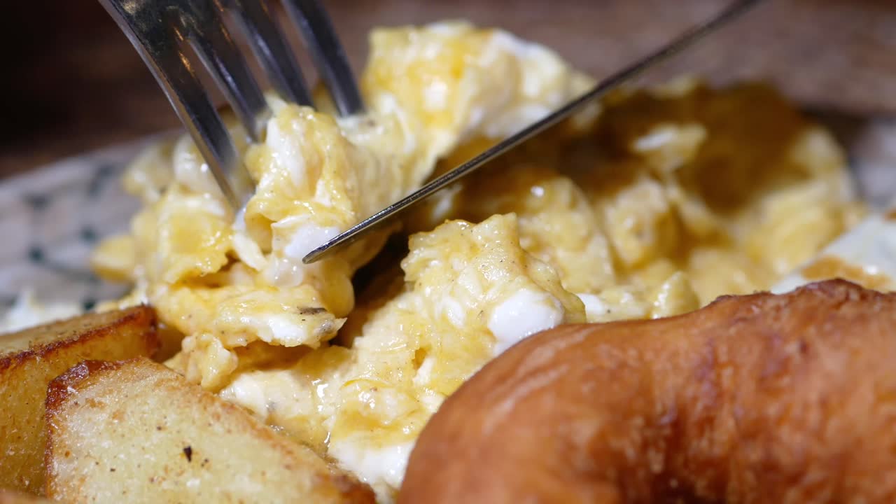 Scrambled eggs with fries and donut