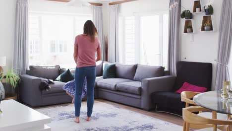 Caucasian-mother-and-daughter-having-fun-dancing-in-living-room