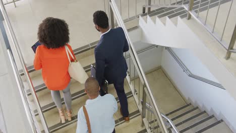 Happy-diverse-business-people-going-up-stairs-at-office,-slow-motion