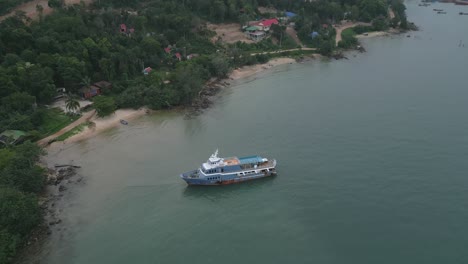 a stranded boat rests on the sandy shore of a tropical island.