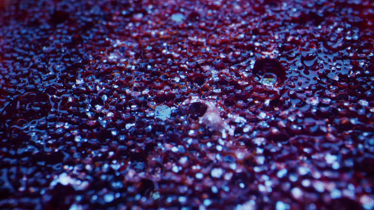 Close-up view of a textured surface with a mix of purple and red tones.