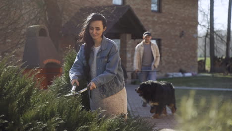 vista en primer plano de la mujer caucásica podando las plantas en el campo. entonces su pareja la abraza