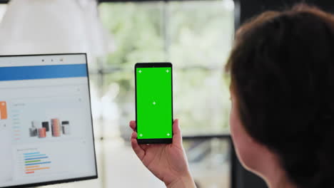 el trabajador examina el teléfono con pantalla verde