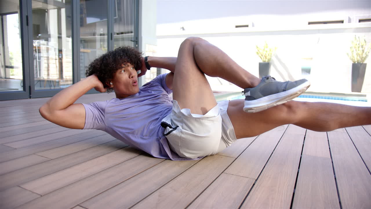 un joven en forma está haciendo ejercicio al aire libre en el patio trasero de su casa
