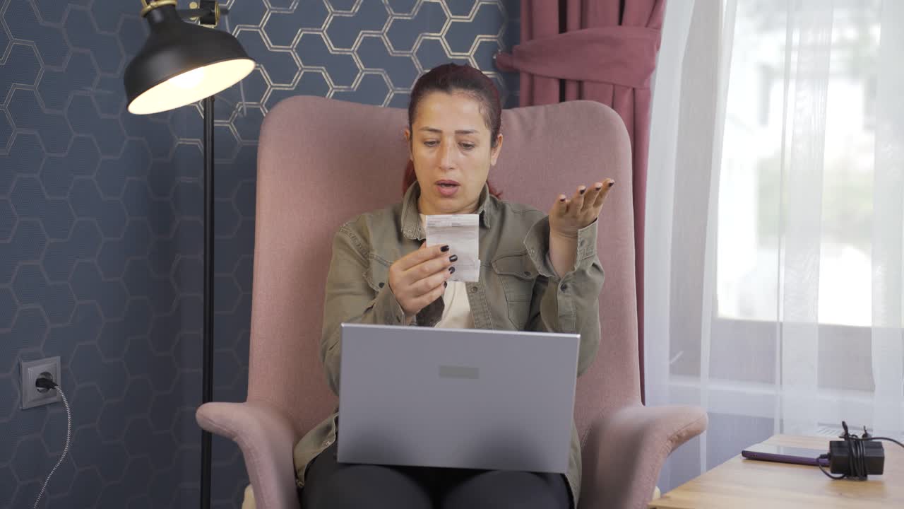 높은 전기 요금을 보고 있는 여자가 조명을 꺼 ⁇ 니다.