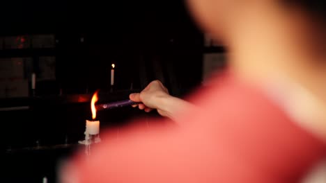 lighting candles and incense in a religious setting