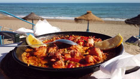 paella con vista a la playa en una playa soleada en marbella, málaga, españa