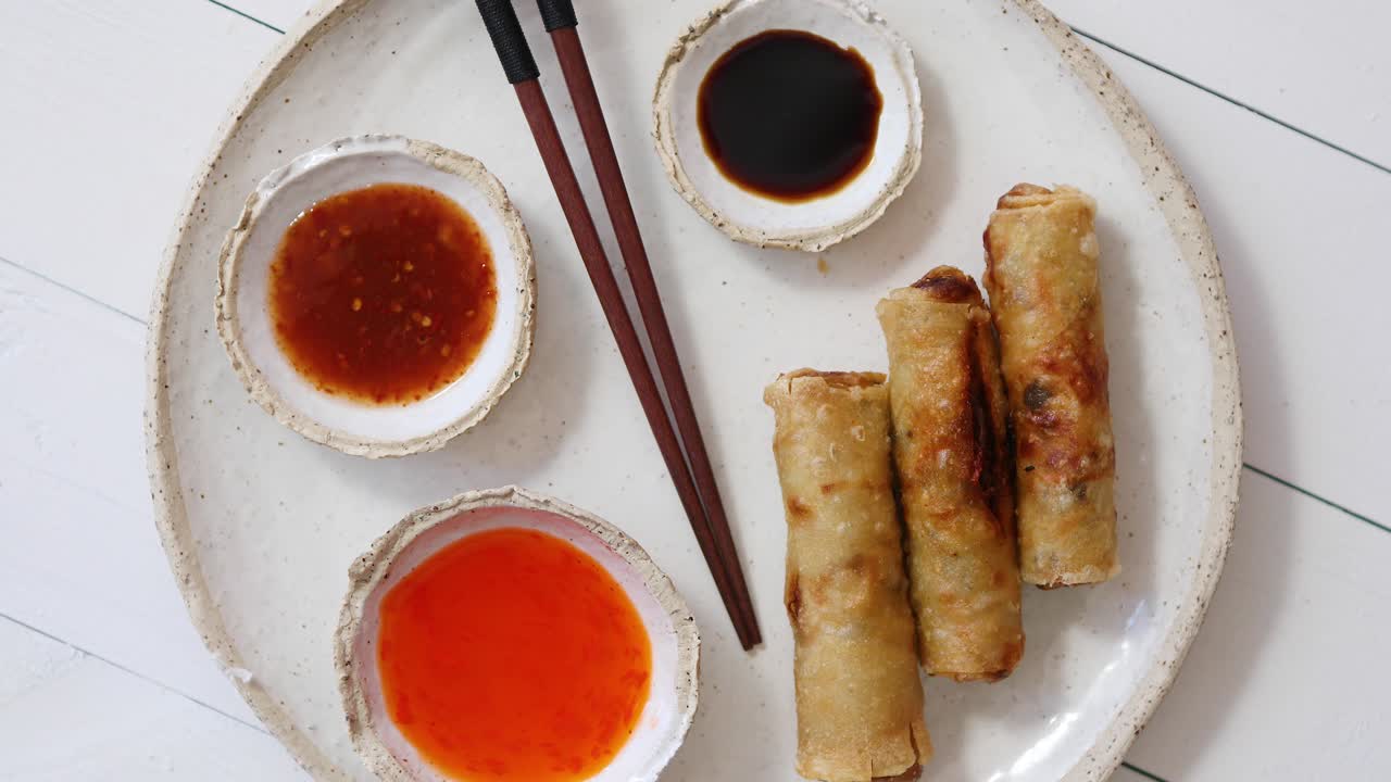 Lumpia goreng tradisional Tiongkok, Thailand, atau Vietnam, atau nem, disajikan di piring keramik