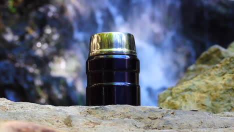 travel flask at the waterfall, advertising footage for travellers