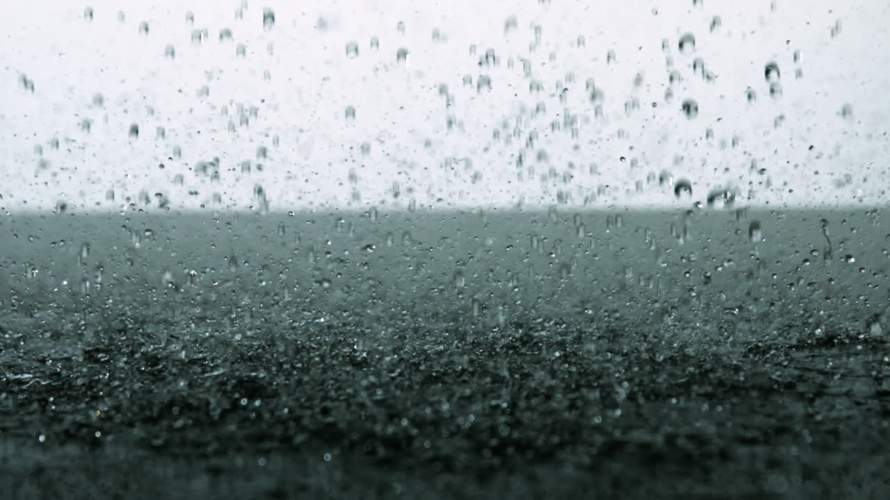 Rain falling on black surface