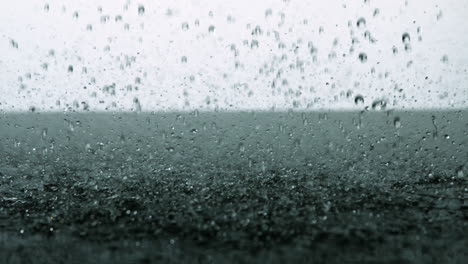 Rain-falling-on-black-surface