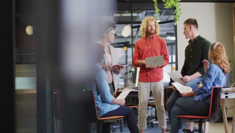 happy diverse business people discussing work with documents at office