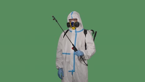 medical worker in a protective suit against bioviral hazard spray of chemicals for disinfection against coronavirus. isolated a green screen, chroma key. slow motion. close up