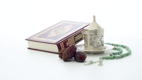 islamic holy book with rosary on a turnable white background, translation is quran kareem in arabic