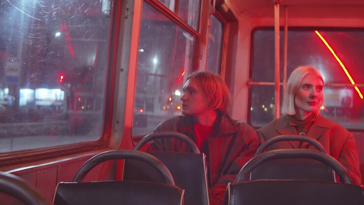 Young Man and Woman Riding Trolleybus in Night