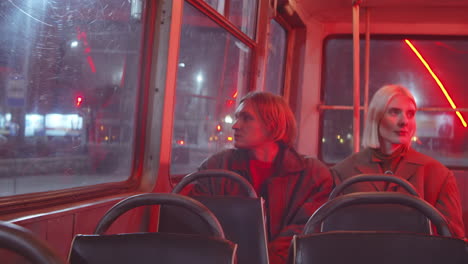 young man and woman riding trolleybus in night