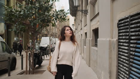 mujer asombrada comprobando la arquitectura de los edificios en la calle