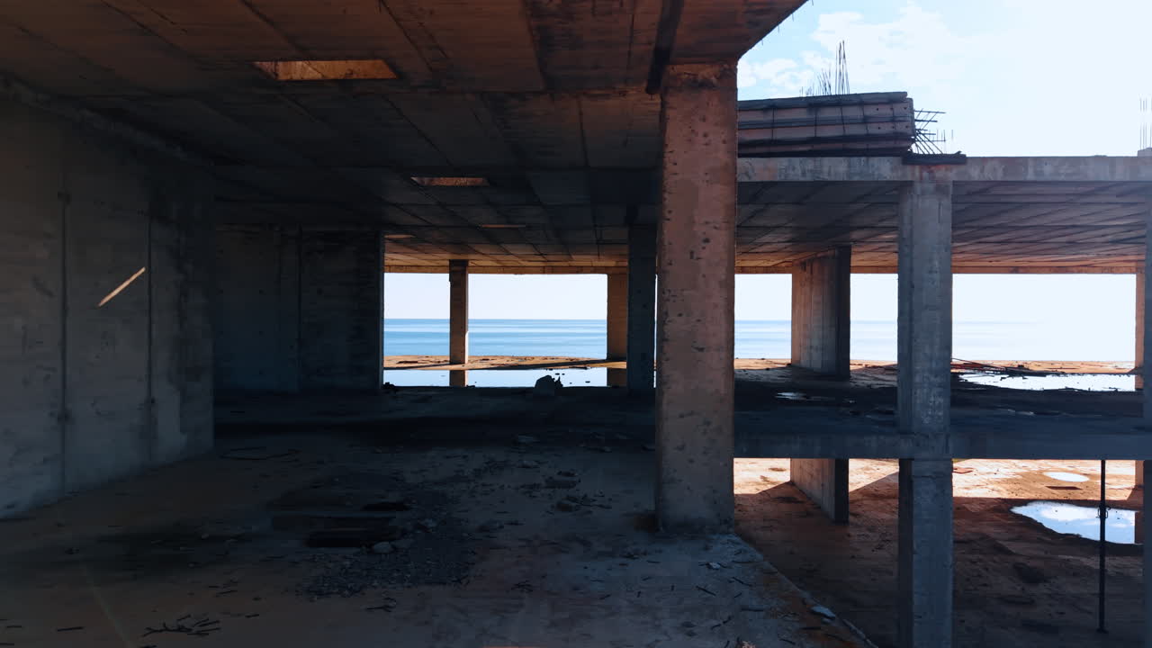 Muovendosi all'interno dei piani dell'edificio senza pareti esterne. Vista sul paesaggio marino sullo sfondo.