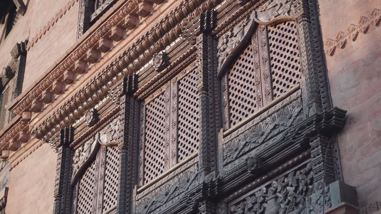 Impressionanti intagli in legno pregiato delle finestre di una casa antica a Kathmandu, Nepal - Ripresa dal basso.