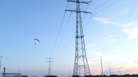 tall power lines against a colorful sunset sky in an industrial landscape