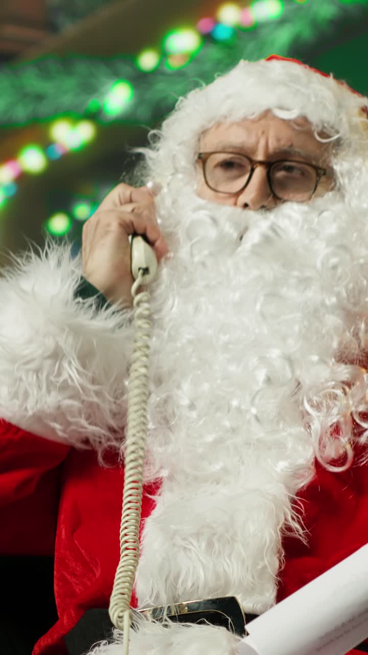 Babbo Natale che risponde a una telefonata e legge una lista