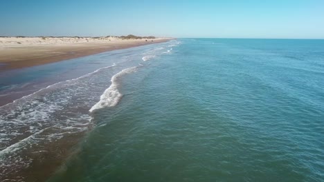 Stationäre-Luftdrohnenansicht-Eines-Fahrzeugs,-Das-Sich-An-Einem-Sonnigen-Nachmittag-Am-Strand-Auf-Einer-Barriereinsel-An-Der-Golfküste-Nähert---South-Padre-Island,-Texas