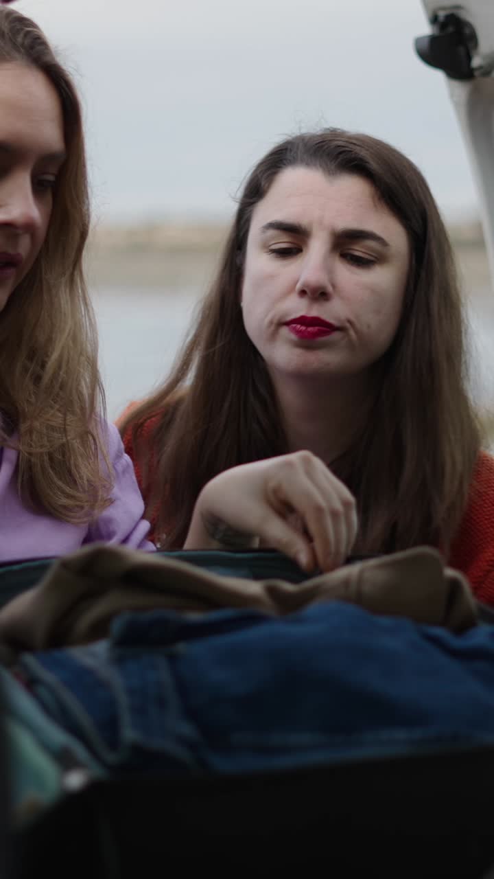 Women Packing Clothing in Trunk