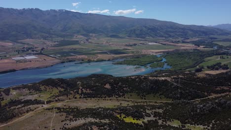 Drone-view-of-Lake-Dunstan-and-mountains-on-a-sunny-day-in-Otago,-New-Zealand