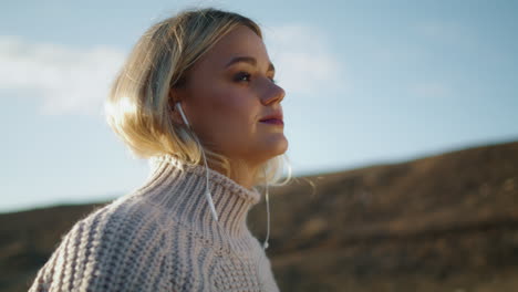 Chica-Caminando-Con-Auriculares-Fondo-De-Naturaleza.-Señora-Rubia-Escuchando-Música